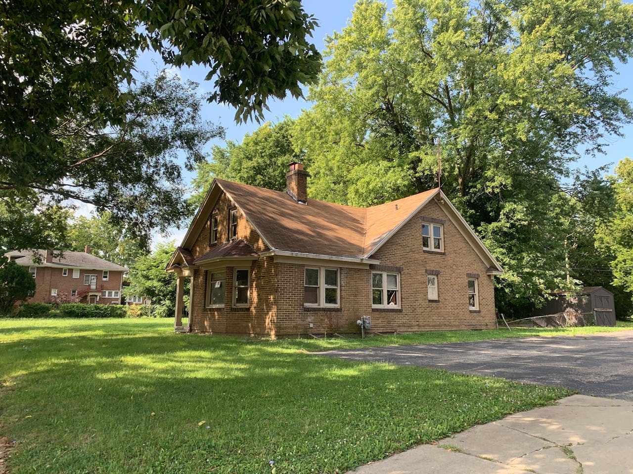 Charming brick house surrounded by trees in a quiet Decatur neighborhood. Perfect for real estate and lifestyle imagery.